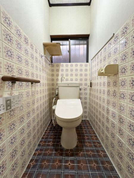 緑が丘4丁目中古のトイレ|レトロな雰囲気を感じさせるタイルデザインが目を引きます。窓から自然光が入り空間が明るく保たれています。手すりが設置されており安心して利用できます。