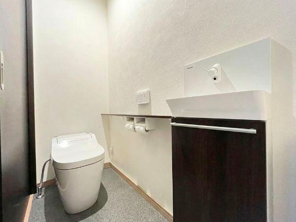 大字森　戸建てのトイレ|トイレ空間がすっきりとしたデザインで落ち着いた色調が特徴です。手洗いカウンターが付いており機能的な印象です。ペーパー収納も使いやすい位置に配置されています。