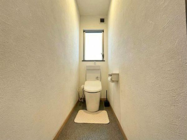 大字森　戸建てのトイレ|シンプルで無駄のないデザインのトイレです。窓があるため明るさを感じられます。清潔感のある空間が広がっています。壁面の質感がやさしい印象を与えます。