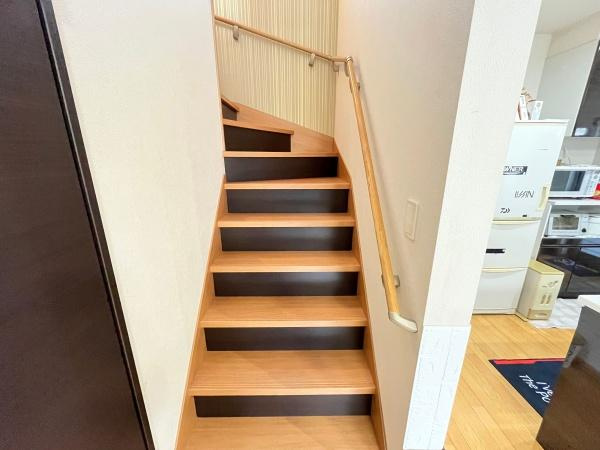 大字森　戸建ての内装|手すり付きで昇り降りがしやすい階段です。木目調のデザインが室内に調和しています。
