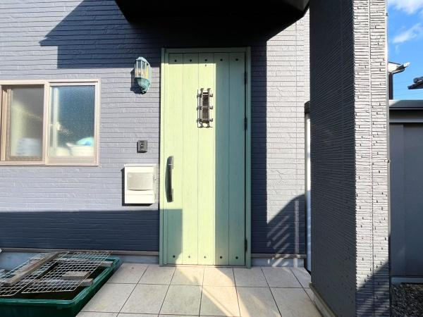 大字森　戸建ての玄関|ナチュラルな色合いの玄関ドアが外観のアクセントになっています。タイル張りの玄関アプローチが清潔感を演出します。壁の質感と相まってシンプルながらも印象的な玄関です。