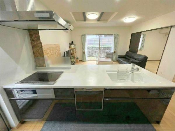 大字森　戸建てのキッチン|広々としたカウンターが印象的なキッチンです。IHコンロとシンクが使いやすく配置されています。リビングと一体感のある開放的な空間です。収納が充実していてすっきりとした印象です。