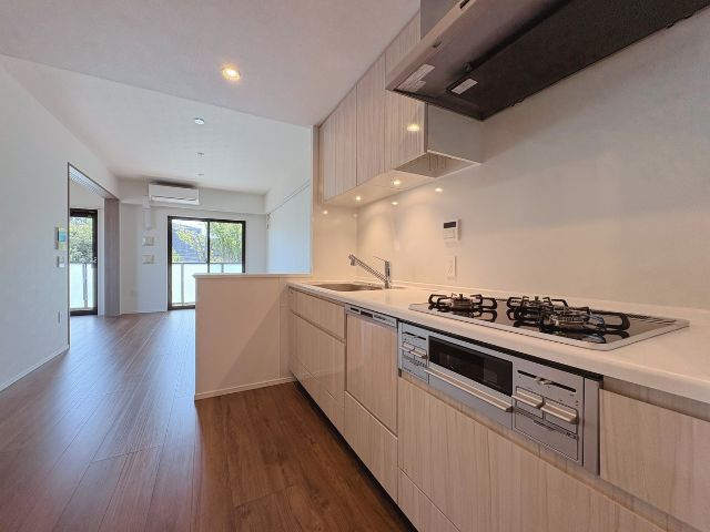 アンビシャスガーデン鶴瀬 のキッチン|ナチュラルな木目が美しい、温かみのあるキッチン空間