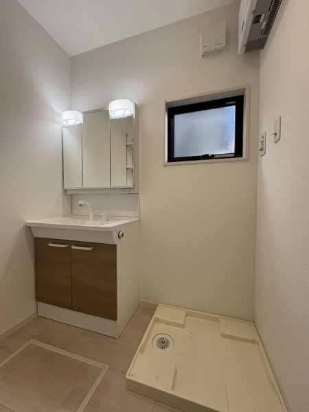 松山市空港通二丁目の独立洗面台|朝の身支度がスムーズに進む機能的な洗面スペース。2022年築ならではの最新設備が整い、洗濯機からの動線も考えられた設計。毎日のお洗濯も効率よく進み、家事の合間に一息つく時間も作れそう。