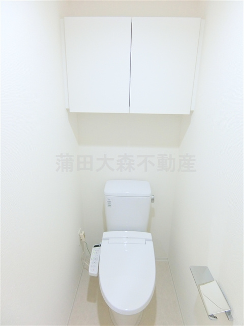 ブライズ大森東QUATTROのトイレ|吊戸棚と温水洗浄便座付きのトイレ