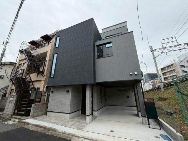 【外観】 | 北側公道に面した平坦地で、大切なお車を格納できる車庫も完備。周辺にはスーパー（徒歩2分）や小学校（徒歩5分）が揃い、利便性と穏やかな住環境を両立。新しい生活をここからスタートしませんか？