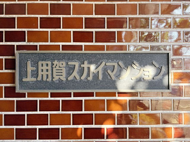 【現況写真】 | 上用賀スカイマンション | エントランスに掲げられた、マンション名を示す館銘板。さほど激しく主張はしませんが、しっかりと掲示されています。～即日のご見学可能～　お問合せはお気軽にどうぞ。