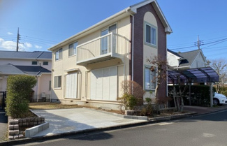 【外観】 | かまとり住宅のリフォーム戸建て「リ・スタイル」 | 明るいベージュの外壁に、アクセントのレンガ調タイルが映える清潔感のある住宅です。1階の大きな窓、整えられた駐車場が、開放的で機能的な印象を与えます。青空の下、シンプルながらも温かみのある佇まいです。