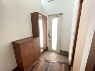 【玄関】 | 東金市季美の森東１丁目　中古戸建　JR外房線【大網駅】 | 吹き抜けから光が差し込み、開放感のある空間。木目調の機能的なシューズボックスは一部がトールサイズで全身鏡が付いており、外出前の身だしなみチェックに便利です。