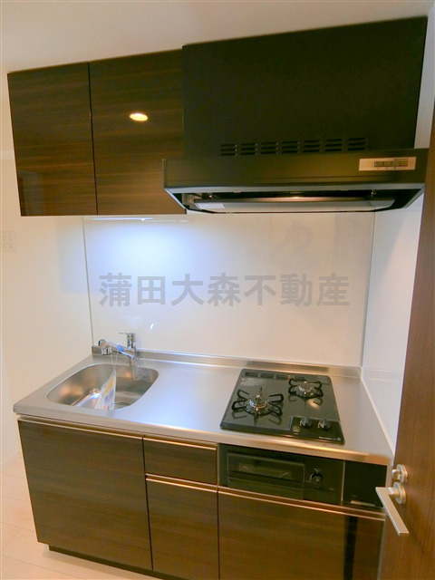 コヌ　ブリーズ蒲田のキッチン|まな板を置く調理スペースのある2口ガスグリル付きシステムキッチン