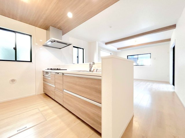 松戸市緑ケ丘２期　全２邸のキッチン|【システムキッチン】豊富な収納はもちろん、大型シンクに３口グリル付きコンロ・食洗機・浄水器など使いやすさ重視の対面式システムキッチン。ご家族と楽しく会話をしながら料理もできます♪※写真は施工例です