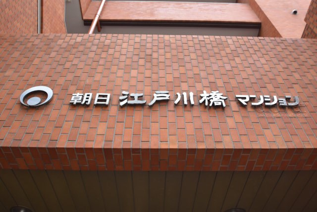 【現況写真】 | 朝日江戸川橋マンション | エントランスに掲げられた、マンション名を示す館銘板。さほど激しく主張はしませんが、しっかりと掲示されています。～即日のご見学可能～　お問合せはお気軽にどうぞ。
