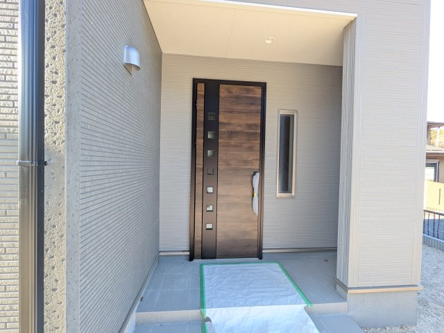 小美玉市小川第1　新築戸建　2号棟の玄関|お洒落な玄関ドアと洗練された外壁デザイン。家の顔にふさわしい上質な佇まいで、ご家族やお客様を迎えます。