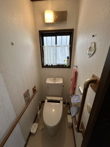 安佐北区亀山南3丁目　土地建物のトイレ|窓付きで自然光が入り換気もしやすい清潔感のあるトイレ空間です。手すりが両側に設置されており立ち座りの
