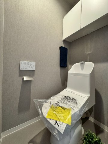 ロイヤルシャトー寝屋川オークビルのトイレ|吊戸棚付きの温水洗浄便座です。