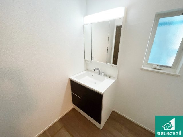 京都市伏見区羽束師鴨川町　第3期　新築一戸建ての独立洗面台|清潔感のある洗面台です。フラットな鏡は掃除がしやすく毎日清潔！鏡裏には収納があるのでスッキリとした洗面台が保てます。