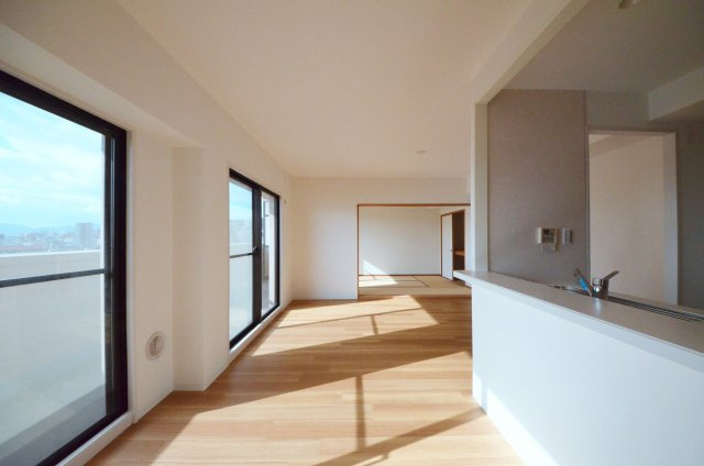 サンシティ庚午の居間・リビング|南西向きの広く明るいリビング空間。オープンタイプの対面式キッチンでリビングが隅まで見渡せます。キッチンにいながら小さなお子様にも目が届き安心です。