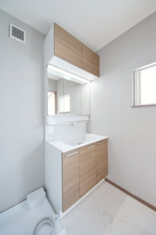 東原三丁目の洗面所|清潔感あふれる白を基調としたシャワー付洗面台と洗面室。収納棚もある余裕のスペース。窓もあり明るく通気も良いです。