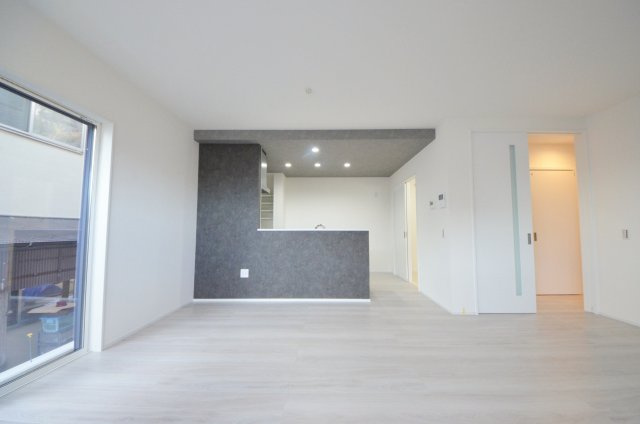 皆賀二丁目の居間・リビング|陽当たりが良く、窓の多いリビング空間。オープンタイプの対面式キッチンでリビングが隅まで見渡せます。キッチンにいながら小さなお子様にも目が届き安心です。