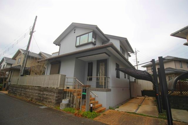 下野市烏ケ森1丁目の外観|落ち着いたグレーの外壁がスタイリッシュな印象の外観。屋根付きカーポート付きで大切なお車を雨や汚れから守れそうです。玄関までの階段アプローチも整備され、上品な住まいの雰囲気が感じられます。