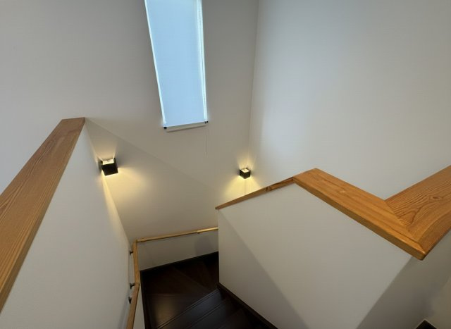 モダンな外観とウッドデッキ！文苑2丁目で叶える開放感溢れる暮らし◎のその他|手すり完備で安心。縦長窓とモダンな照明が彩る開放的な階段。