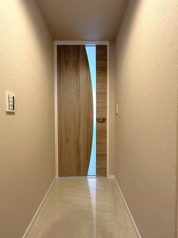 ブリリアタワー東京の玄関|リビングへとつながるホールは大理石調の床材を用いることにより、光の反射で開放感のあるスペースとなっています。リビングドアの月のデザインも一躍かっています。