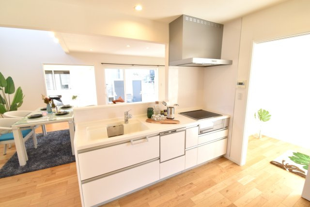 ゼロキューブ　吹き抜けのあるモダン住宅のキッチン|対面キッチンは間取りの中心で、ダイニング・リビング、洋室が見渡せます。食器洗い乾燥機付き！キッチンカウンターは広く、シンクも人工大理石を使っています。IHヒーターで火を使わないので安全です。
