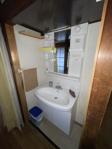 西条市楠　中古住宅の独立洗面台|窓からの採光が心地よい洗面室は、家事の合間のリフレッシュにも最適です。十分なスペースを活かして、タオルや洗剤などのストックもスッキリ収納。機能的な動線が、毎日のルーティンをより軽やかに変えてくれます。