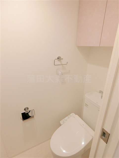 nido KAMATAのトイレ|吊戸棚と温水洗浄便座付きのトイレ