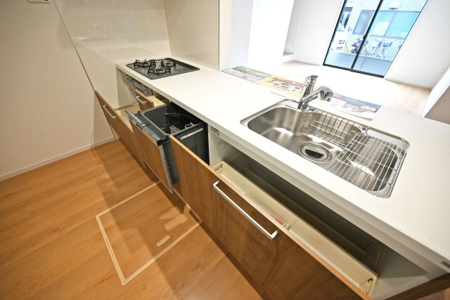 テラシエ大庄中通１丁目新築一戸建て│4LDK+駐車駐輪のキッチン|キッチン天板下いっぱいに収納庫を設けてあります。シンクした収納庫にはナイフホルダーも標準搭載。食器洗い乾燥機や浄水器一体型水栓も標準仕様のユニットが導入されています。