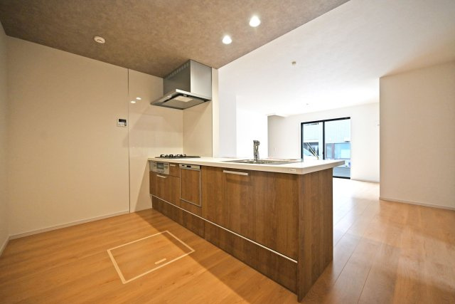 テラシエ大庄中通１丁目新築一戸建て│4LDK+駐車駐輪のキッチン|1階LDKをキッチン越しに撮影した現地内観写真です。 広くて使いやすいキッチンは折り下げ天井を採用しており、 オシャレな空間に仕上がりました。