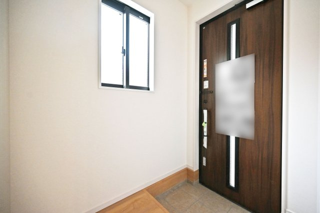 テラシエ大庄中通１丁目新築一戸建て│4LDK+駐車駐輪の玄関|1階玄関をホール側から撮影した内観写真です。 シンプルな玄関扉にシューズボックス、小窓を配置したオーソドックスな玄関です。