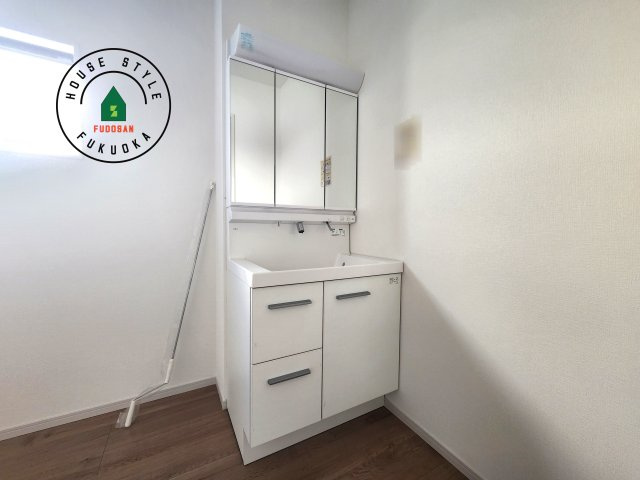 糟屋郡須恵町大字旅石第28-2棟（2号棟）の独立洗面台|毎日使うものだから清潔な空間を保ちたい水回り。洗面にはそんな願いを解消させてくれる収納アイデアが満載です。三面鏡の裏側にはキャビネットが現れ小物から背の高い物まで収納できます。