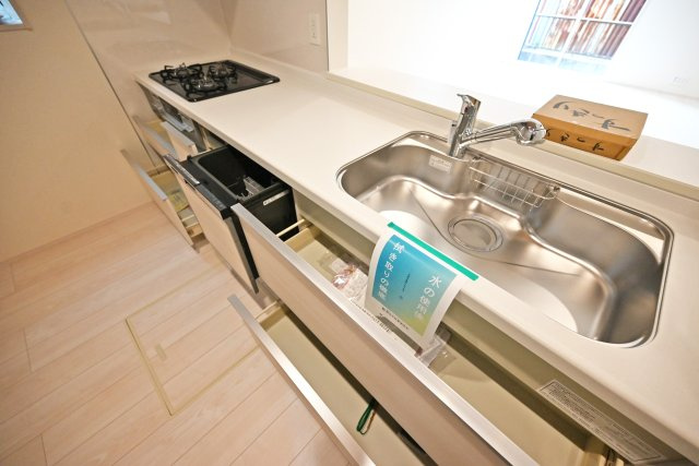 ブルーミングガーデン中野北1丁目新築一戸建│3LDK+インナーガレージのキッチン|ワークトップは十分な広さがあるW2550タイプ。調理台下いっぱいに収納を設け、包丁のホルダーや調味料専用の引き出しも備えています。本分譲地は食洗機が標準装備されています。