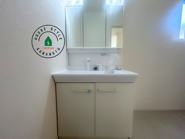 熊本市南区富合町杉島第2-2棟(1号棟)の内観：施工例|毎日使うものだから清潔な空間を保ちたい水回り。洗面にはそんな願いを解消させてくれる収納アイデアが満載です。三面鏡の裏側にはキャビネットが現れ小物から背の高い物まで収納できます。