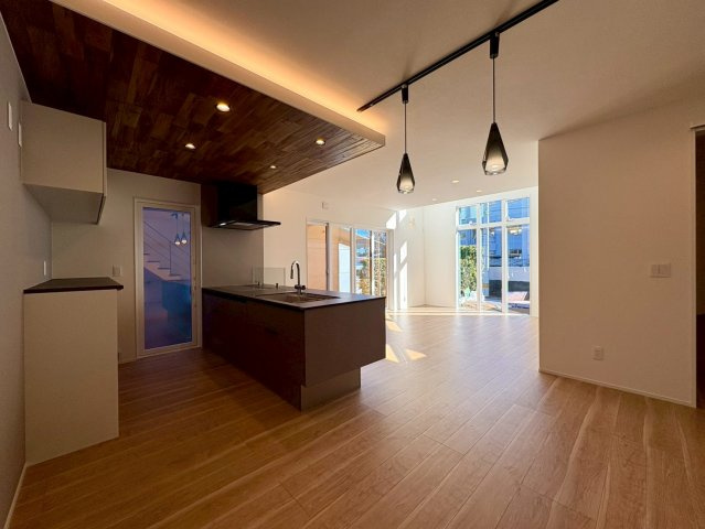 高知市小津町4号地　新築一戸建ての居間・リビング|大きな窓から差し込む自然光と、間接照明が空間に奥行きを生み出します