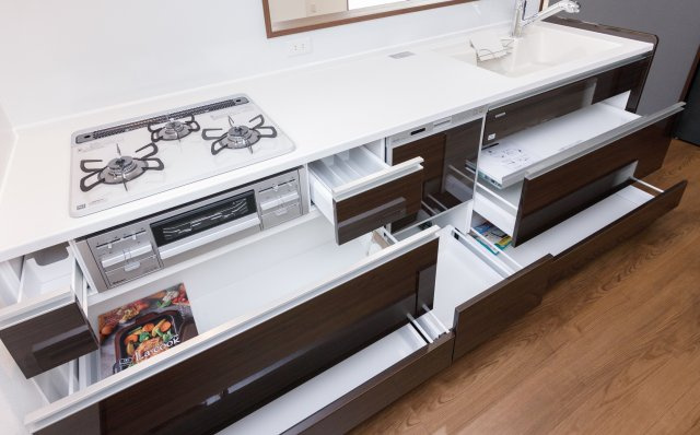 【内観：施工例】 | ライフフィールド岸城町　13号地 | 【キッチン】対面式キッチンで、お子様の遊ぶ姿を見守りながらお料理が可能！大きなお鍋やフライパンも出し入れラクラクな、スライド式の収納です。（同仕様の設備）