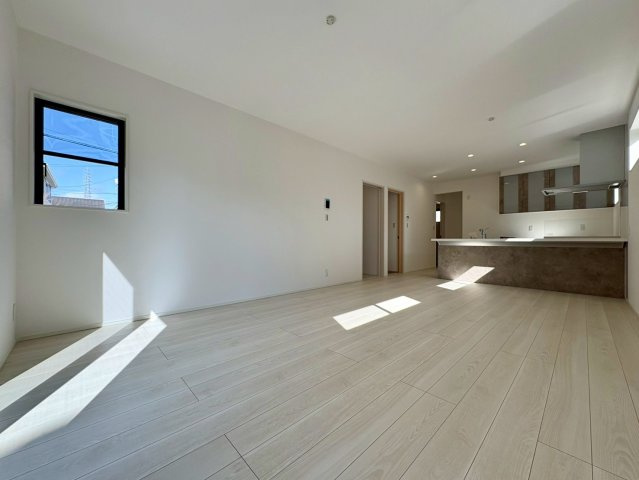 一宮東町１号棟　新築戸建ての居間・リビング|陽光が差し込む明るく開放的なLDK。対面キッチンからリビング全体を見渡せる間取りで、家族との会話も自然と増える空間です。シンプルで上質な内装が、ゆったりとした暮らしを演出します。