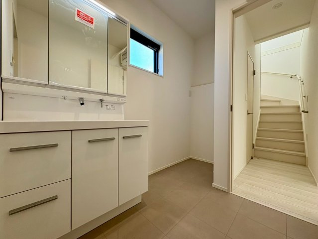 一宮東町１号棟　新築戸建ての独立洗面台|三面鏡付きの洗面化粧台で収納も充実。広さにゆとりのある洗面スペースで朝の身支度もスムーズ。窓付きで明るく、換気もしやすい快適な空間です。