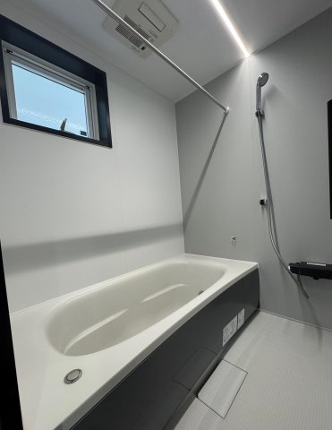 高知市朝倉本町1丁目　建売住宅の浴室|清潔感あふれるシンプルな浴室。
明るいホワイトとグレーのコントラストが上品で、日々のバスタイムを心地よい空間に。浴室乾燥機付きで雨の日も安心です。