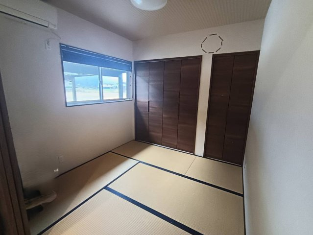 西条市下島山甲2055-87　中古戸建の和室|LDKと隣接した和室は、扉を開放することで18畳超の大空間をさらに広々と活用できます。2020年築の新しい畳の香りに包まれ、お子様の遊び場や、家事の合間のリラックススペースとして多目的に活躍します。