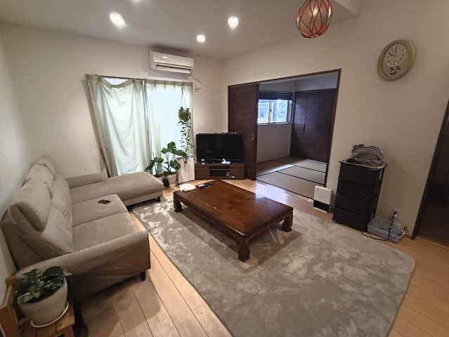 西条市下島山甲2055-87　中古戸建の居間・リビング|木の温もりを感じる洗練されたリビング。18畳超の広さは家具の配置も自由自在で、自分たちの理想のスタイルを形にできます。庭へと繋がる視界の広がりが、日々の生活に彩りとゆとりを与えてくれます。