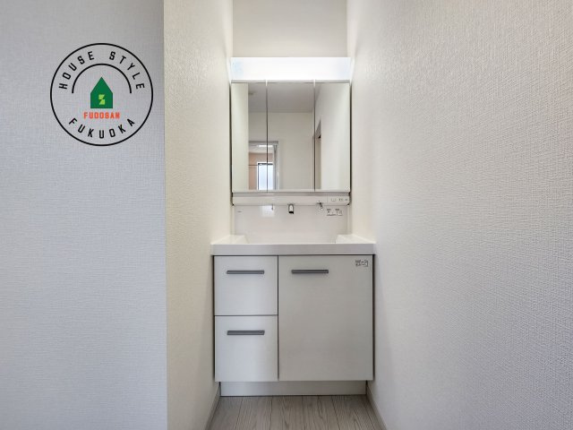 糟屋郡須恵町旅石第26-2棟（2号棟）の独立洗面台|毎日使うものだから清潔な空間を保ちたい水回り。洗面にはそんな願いを解消させてくれる収納アイデアが満載です。三面鏡の裏側にはキャビネットが現れ小物から背の高い物まで収納できます。