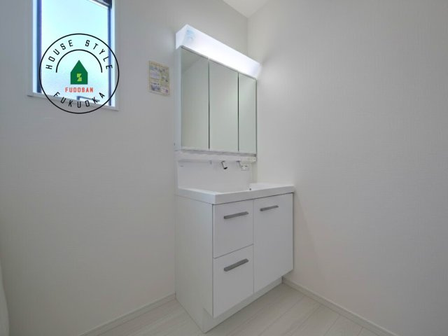 福岡市南区西長住2丁目第2-5棟（2号棟）の内観：施工例|毎日使うものだから清潔な空間を保ちたい水回り。洗面にはそんな願いを解消させてくれる収納アイデアが満載です。三面鏡の裏側にはキャビネットが現れ小物から背の高い物まで収納できます。