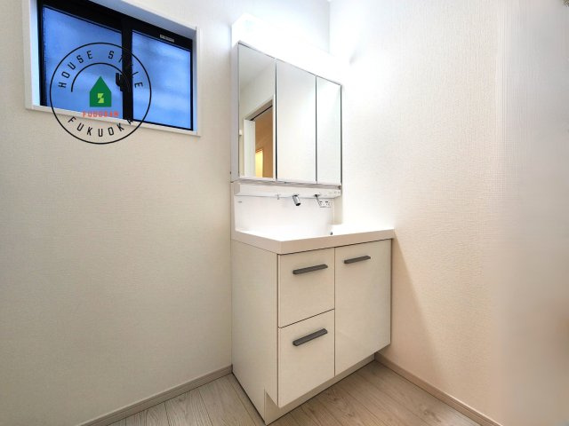 福岡市南区西長住2丁目第2-5棟（4号棟）の内観：施工例|毎日使うものだから清潔な空間を保ちたい水回り。洗面にはそんな願いを解消させてくれる収納アイデアが満載です。三面鏡の裏側にはキャビネットが現れ小物から背の高い物まで収納できます。