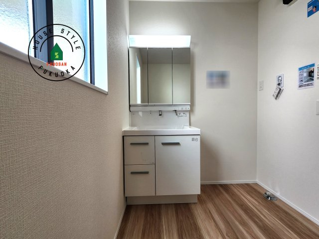 福岡市東区舞松原5丁目第4-2棟（1号棟）の内観：施工例|毎日使うものだから清潔な空間を保ちたい水回り。洗面にはそんな願いを解消させてくれる収納アイデアが満載です。三面鏡の裏側にはキャビネットが現れ小物から背の高い物まで収納できます。