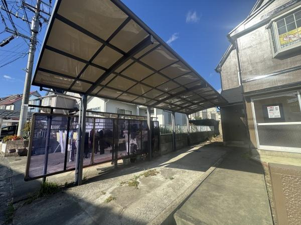 大字横尾　中古の駐車場|広々としたカーポート付きの駐車場です。屋根があるため天候の影響を受けにくい仕様になっています。両側にフェンスが設置されており安心してご利用いただけます。住宅横に隣接しているので出入りも便利です。