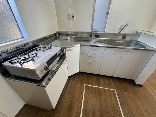 大字横尾　中古のキッチン|L字型のレイアウトで作業効率が良いキッチンです。ガスコンロとシンクがシンプルにまとまり調理や片付けの動線がスムーズです。収納スペースも確保されており使い勝手を意識した設計となっています。