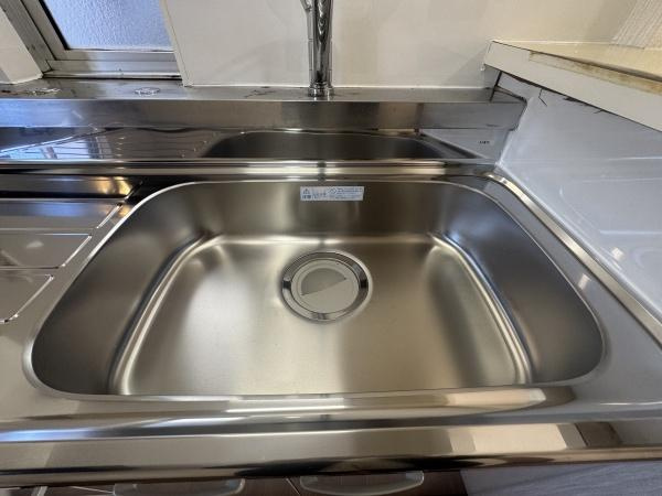 大字横尾　中古のキッチン|ステンレス製のシンクが清潔感を演出しています。シンクまわりが広く調理や片付けが快適に行えます。窓が近く手元が明るいのも特長です。シンプルで扱いやすいキッチンです。