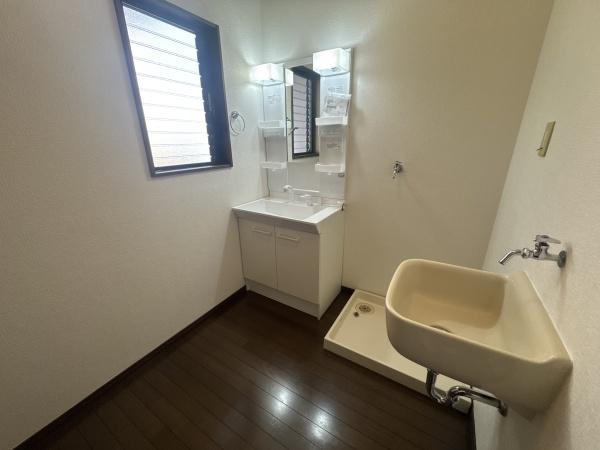 大字常行　中古の独立洗面台|窓からの採光が期待できる洗面所です。洗面台は収納スペースも備え付けられていて便利です。独立した洗濯機置き場とシンクも設置されています。床は落ち着いた色合いで清潔感があります。